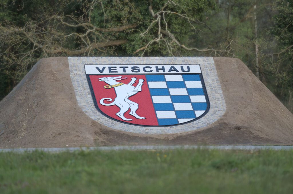 Wappen Vetschau, Grundgestell, Schriftzug und Figur aus Polymerbeton mit fest gebundenen farbigen Splitten und umlaufender Pflasterzeile