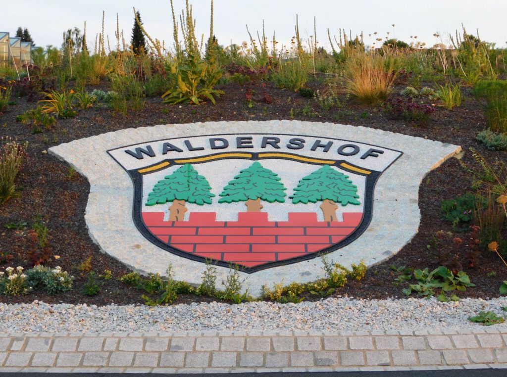 Wappen Waldershof im Kreisverkehr, Grundgestell und Figuren aus Polymerbeton mit fest gebundenen farbigen Splitten und umlaufender Pflasterzeile